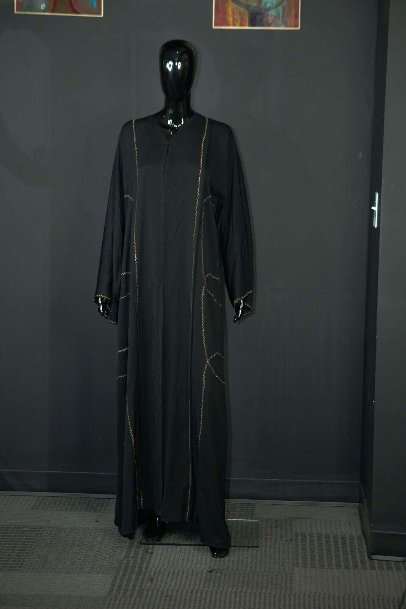 Black abaya with intricate designs on display at Oumy Beauty Studio